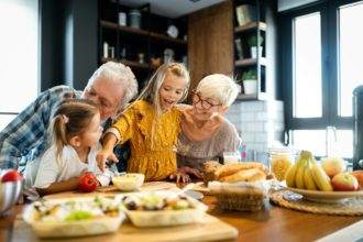 Happy grandchildrens girls having breakfast with her grandparents